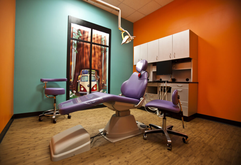 A dentist's office with a purple chair and chair.