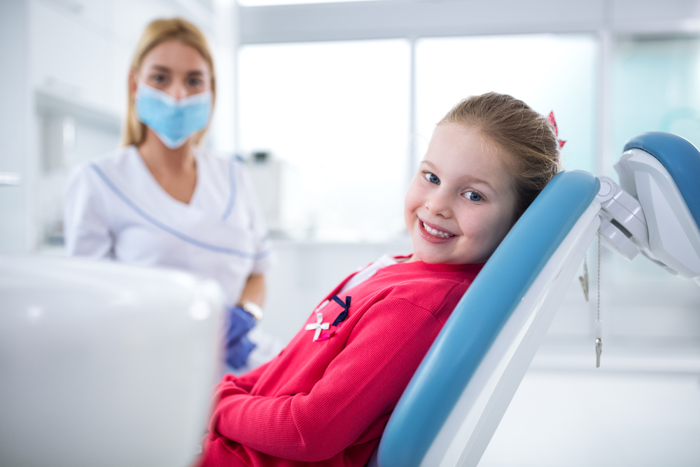 A girl sitting in a dentist chair.