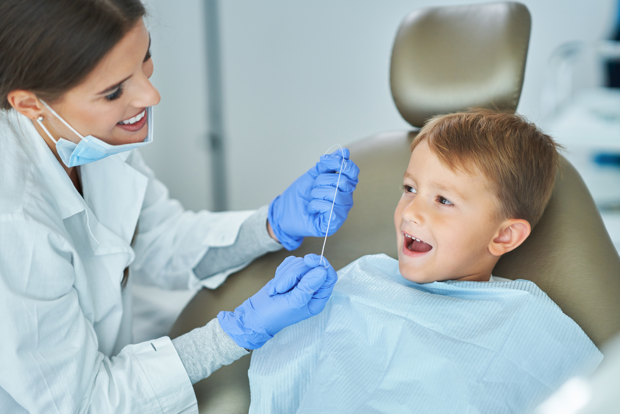 A young boy is being examined by a dentist.