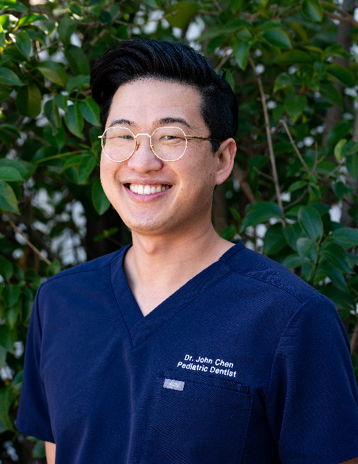 A smiling asian man in scrubs.