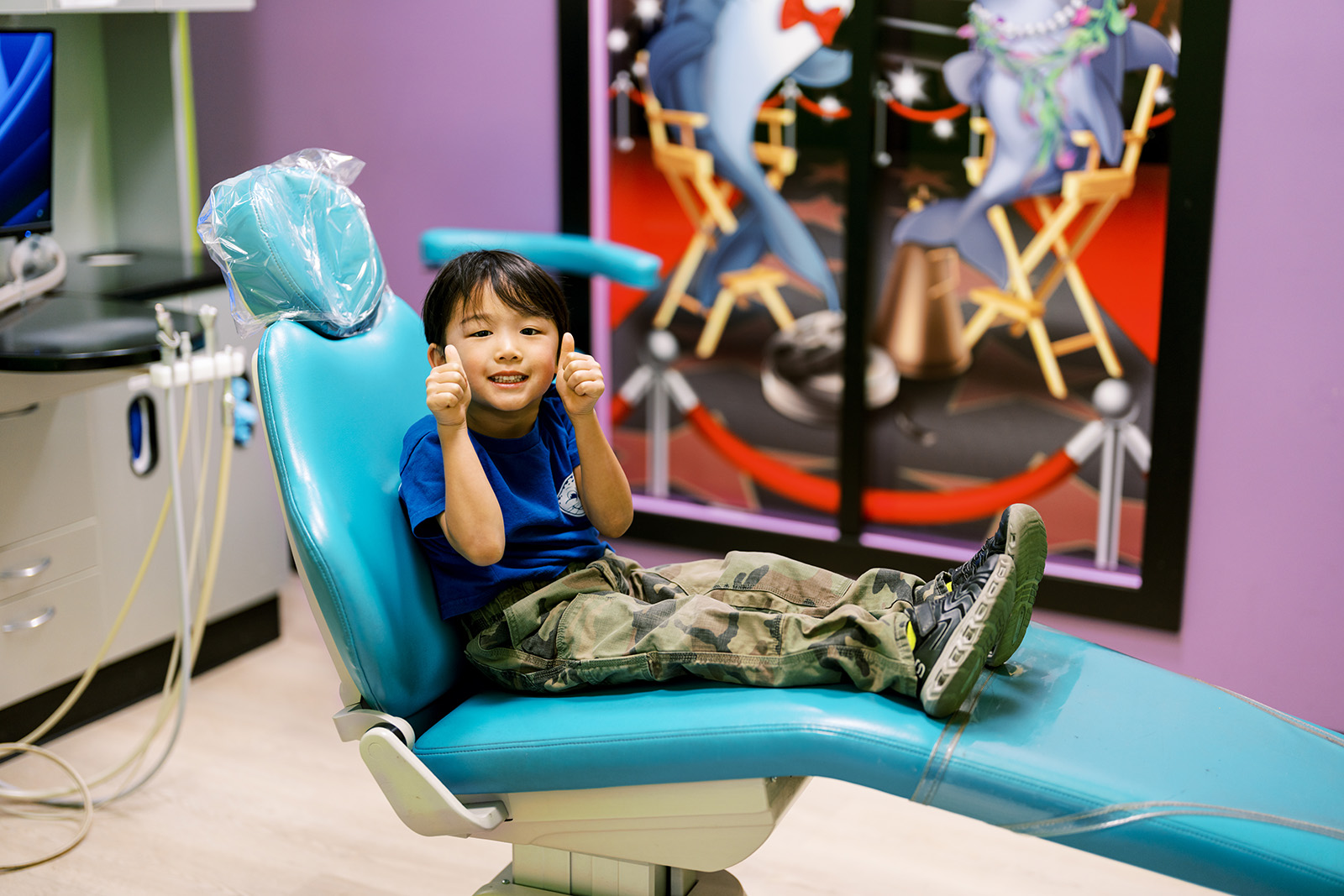A dentist's office with a purple chair and chair.
